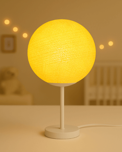 Gelbe Tischleuchte mit handgefertigter Kugel und stabilem weißen Standfuß. Diese LED Lampe sorgt für sanftes, augenfreundliches Licht im Kinderzimmer, Babyzimmer oder Jugendzimmer und bringt warme Gemütlichkeit auf den Nachttisch.