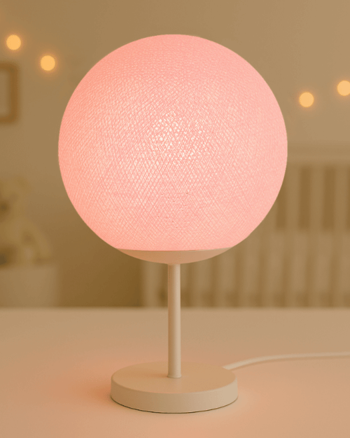 LED Tischlampe mit handgefertigter Baumwollkugel in Rosa auf weißem Standfuß; warmweißes LED-Licht sorgt für eine sanfte, gemütliche Stimmung im Kinderzimmer.
