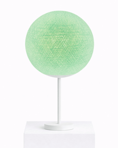 Mintgrüne Tischlampe mit handgearbeiteter Baumwollkugel auf weißem Standfuß; sanftes, warmweißes LED-Nachtlicht auf dem Nachttisch im Kinderzimmer.